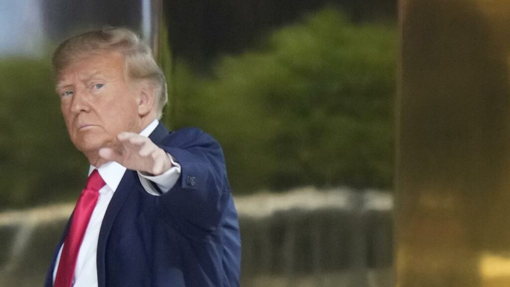 Donald Trump waves to people behind barricades after arriving at Trump Tower before his arraignment.
