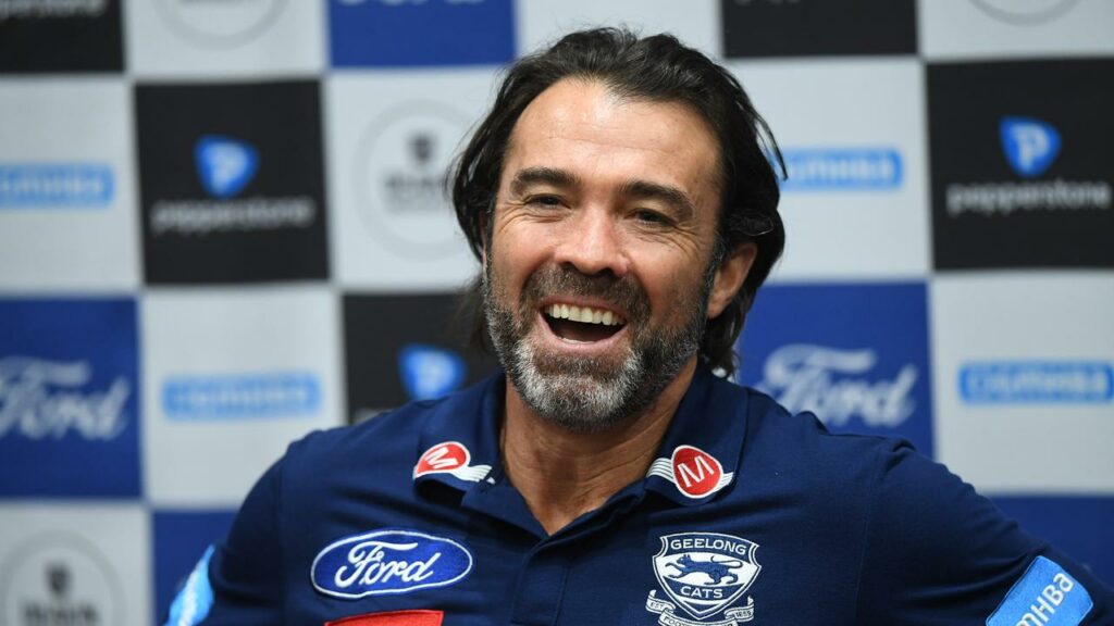 Chris Scott will lead the Cats against his twin brother Brad’s Bombers in Geelong.