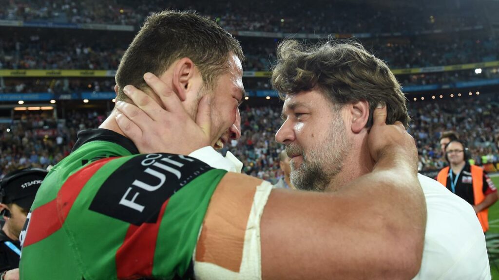 Sam Burgess (left) is hugged by Souths’ co-owner Russell Crowe after the 2014 grand final.
