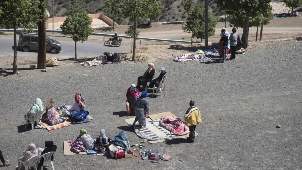 People affected by an earthquake have moved to an area near a highway after homes were damaged.