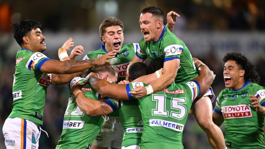 Raiders players swarm around Jamal Fogarty after his match-winning field goal against the Titans.