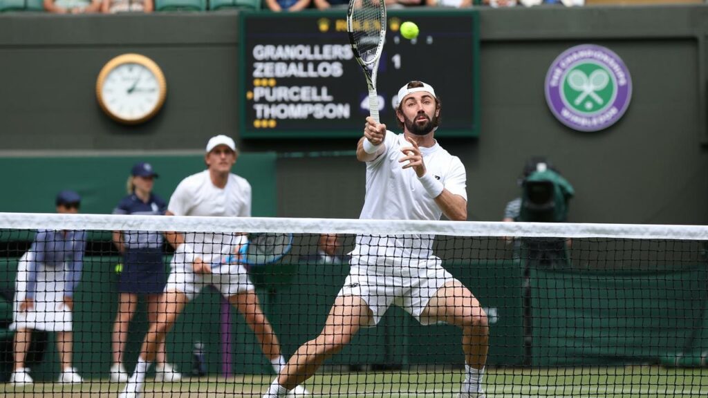 Jordan Thompson volleys with Max Purcell behind him in their men’s singles semi-final Wimbledon win.
