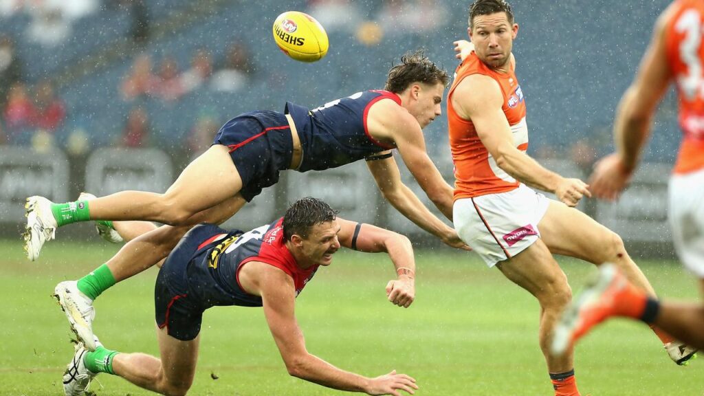 Toby Greene (right) has has helped lift GWS over Melbourne in a helter-skelter finish at a wet MCG.