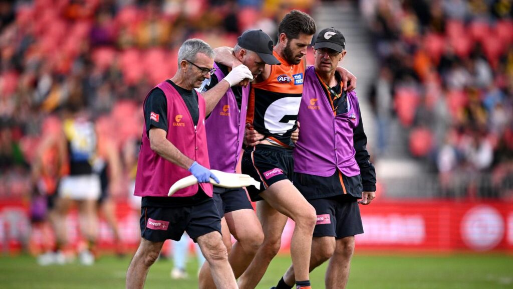 The Giants’ Callan Ward is helped from the field early in the clash against the Tigers.
