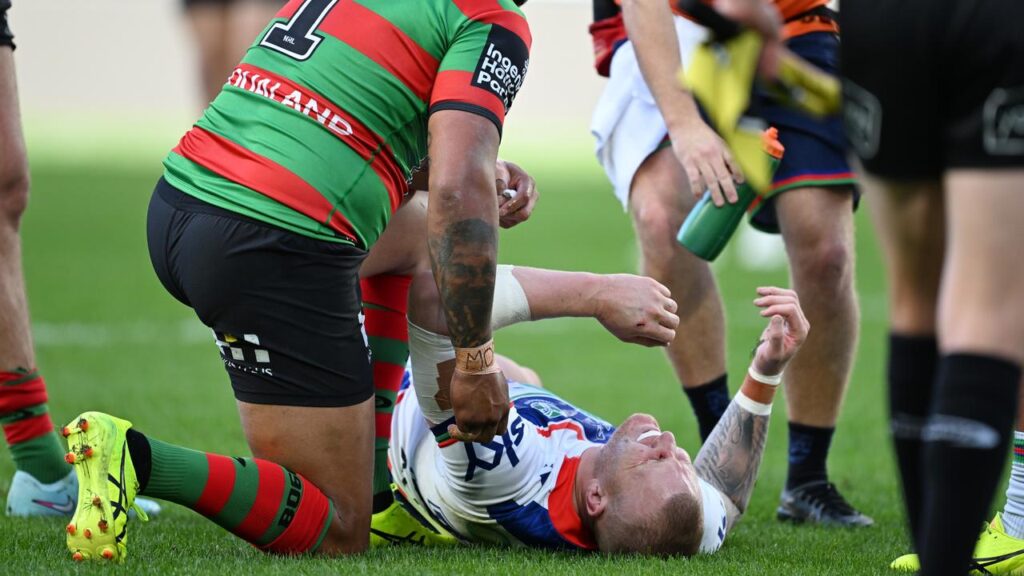 South Sydney’s Latrell Mitchell (left) checks on injured Warrior Mitchell Barnett.