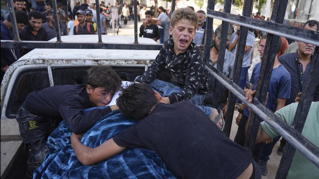 Palestinians children mourn their father, who was killed while heading to an aid distribution hub.