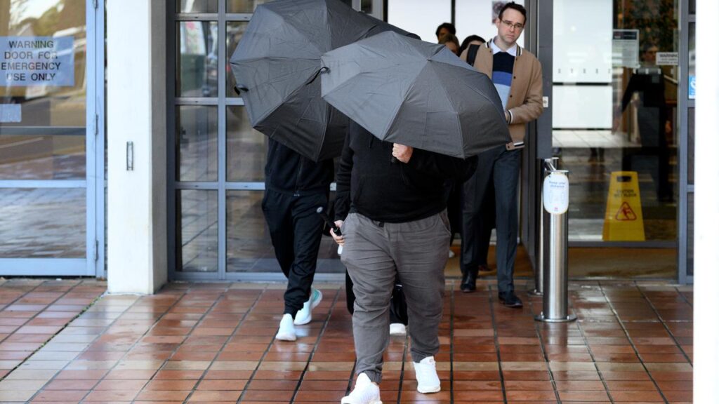 Adam Abdul-Hamid’s family shielded themselves with umbrellas and swore at media as they left court.
