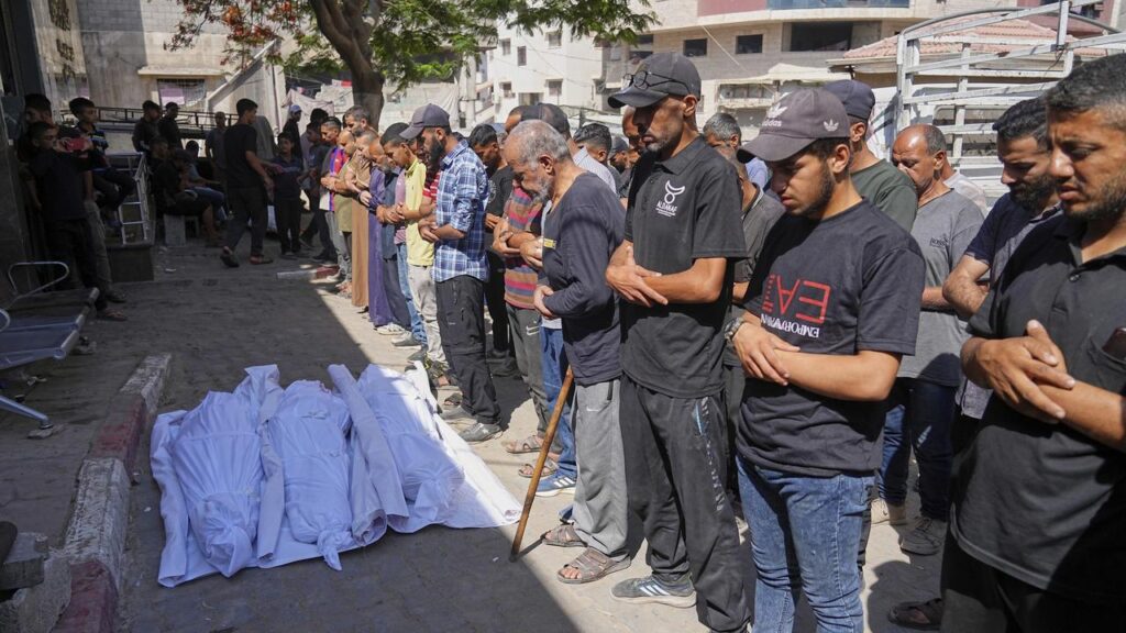 Palestinians pray over the bodies of men killed while trying to collect aid in northern Gaza.