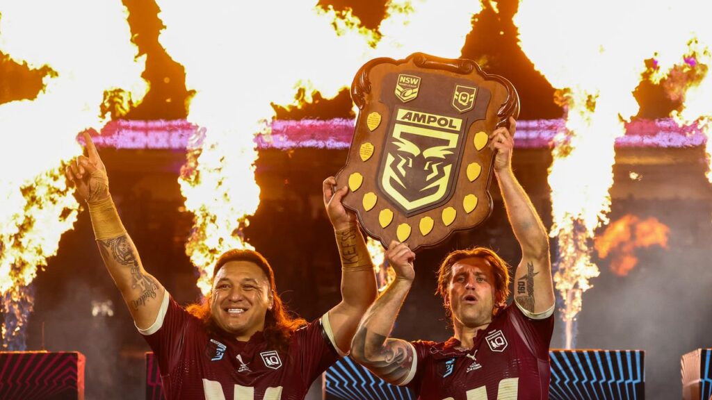 Cameron Munster and Josh Papali’i of the Maroons hold up the shield after their Origin victory.