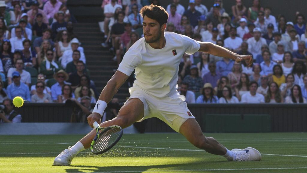 Spain’s Carlos Alcaraz slides out of the shadows to return a shot in his win over Cameron Norrie.