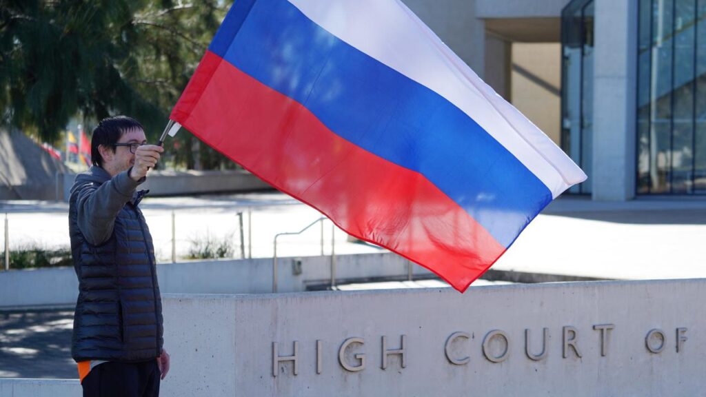 A lone supporter waved the Russian flag outside a High Court hearing on an embassy site dispute.
