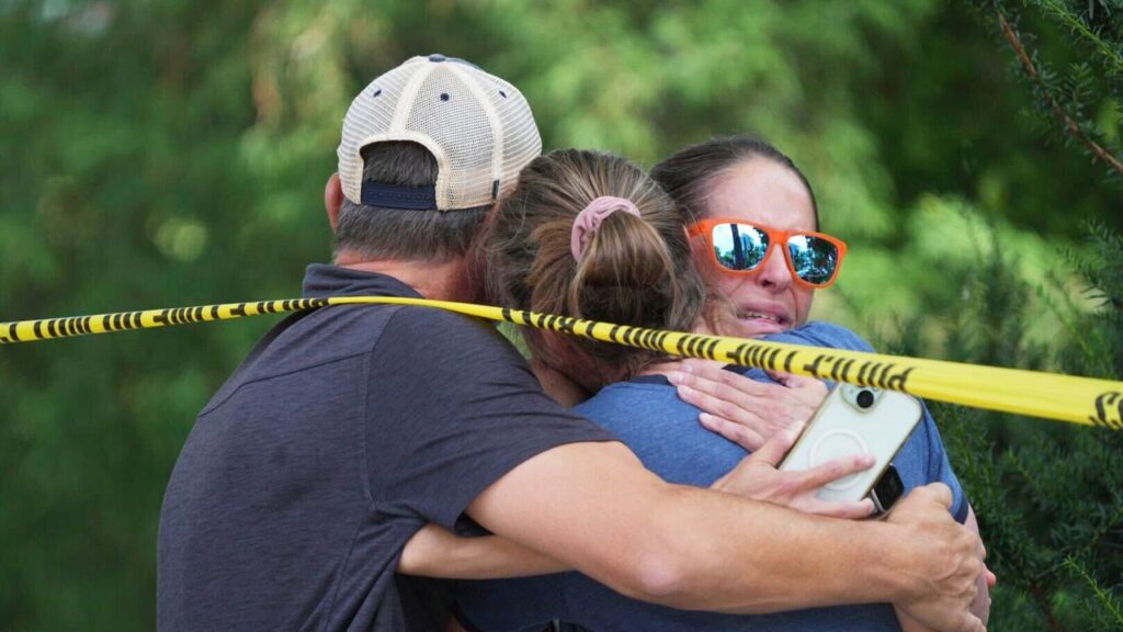 Parents lead students out of the Annunciation Catholic School after a deadly shooting.