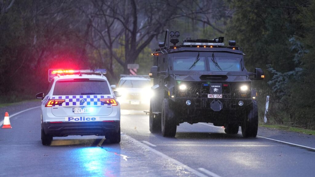 Police continue to search alpine terrain for an armed fugitive who allegedly killed two officers.