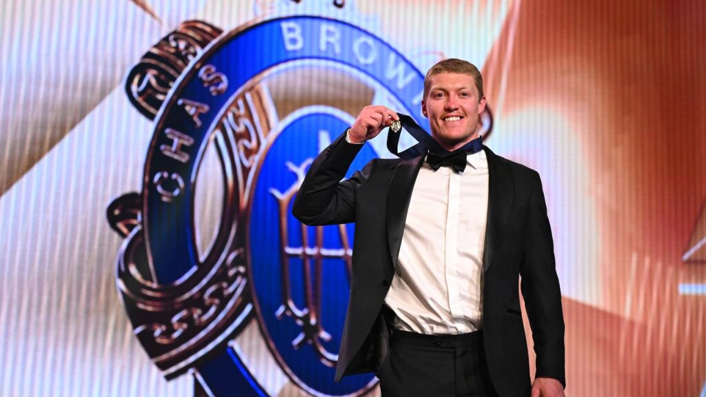 The Suns’ Matt Rowell beams with pride and joy as he shows off the 2025 Brownlow Medal.
