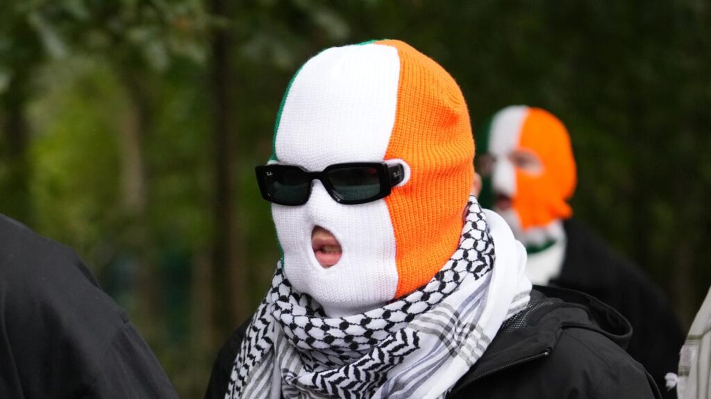 A masked person believed to be Kneecap rapper Mo Chara was photographed attending court.
