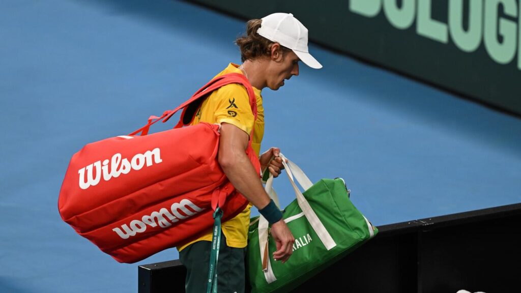 A dejected Alex de Minaur leaves the court after his shock loss in the opening singles rubber.
