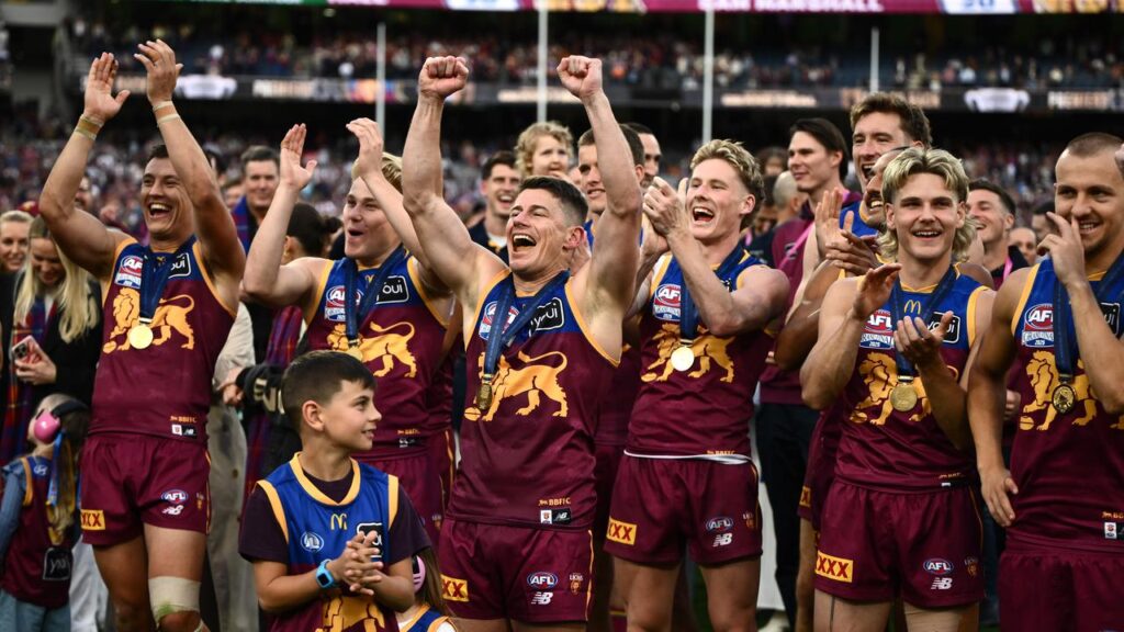 Brisbane players celebrate the club’s second successive AFL premiership.
