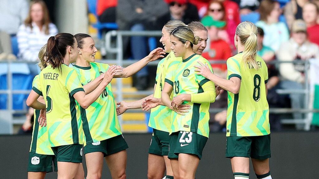 Australia’s Courtney Nevin receives congratulations after opening the scoring against Wales.