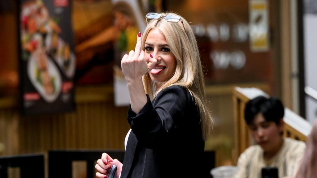 The Bachelor contestant Marjorie Griffiths gestures to media after avoiding jail.