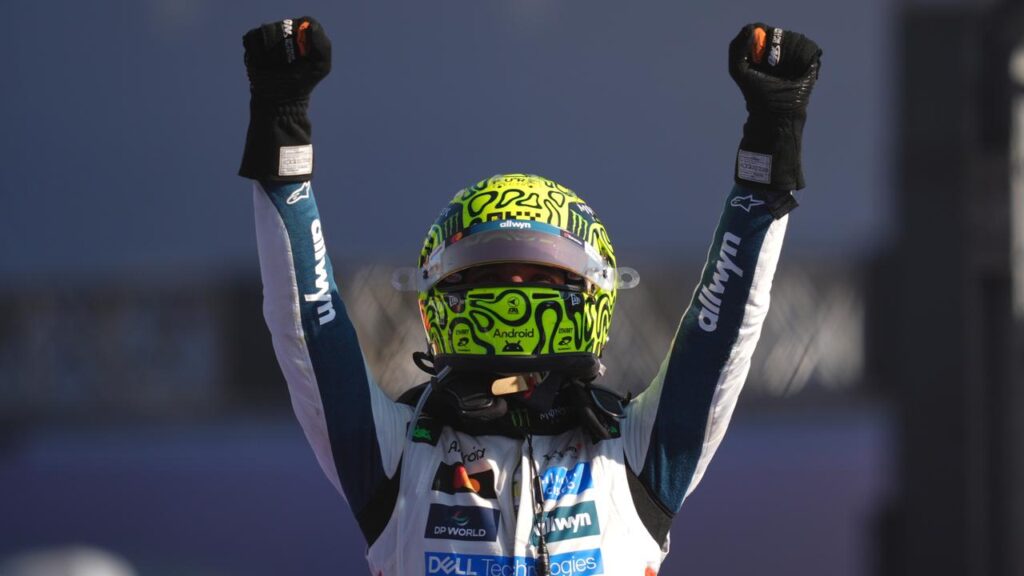 McLaren driver Lando Norris raises his arms in triumph after claiming the Mexico Grand Prix.