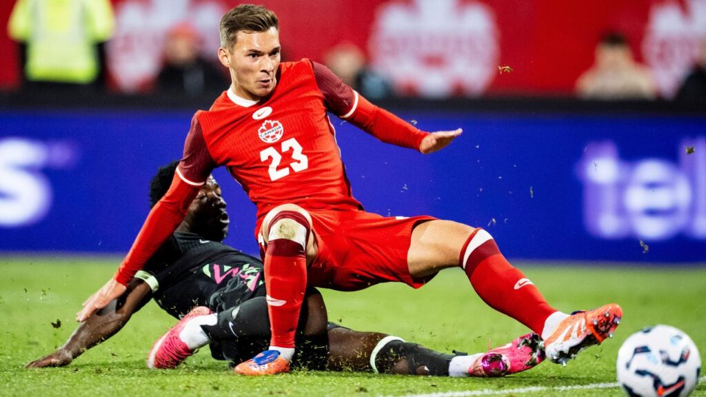 Nestory Irankunda (l) shoots past Canada’s Niko Sigur to score for the Socceroos in the 1-0 win.