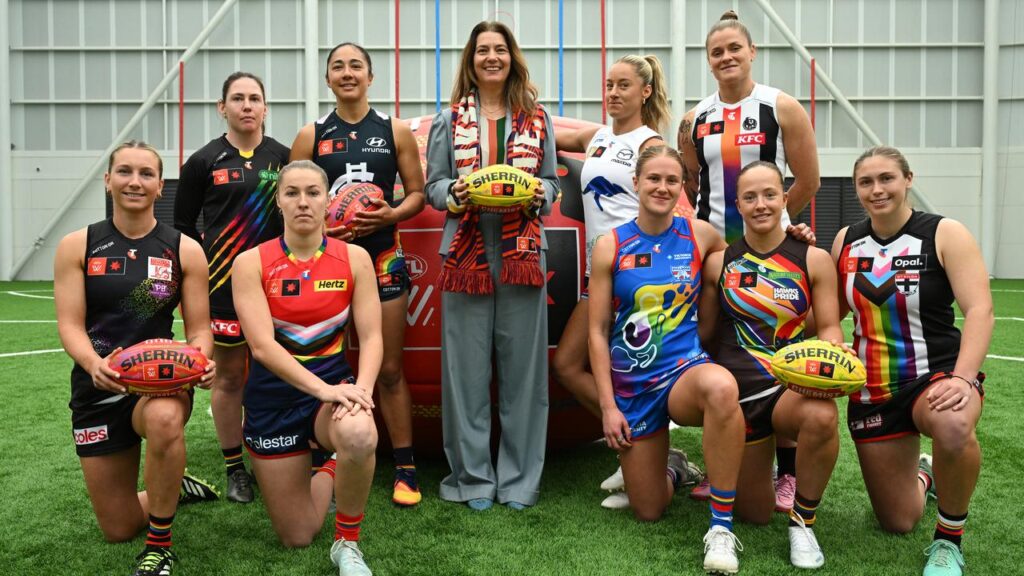 AFLW general manager Emma Moore (c) poses with club representatives ahead of Pride Round.
