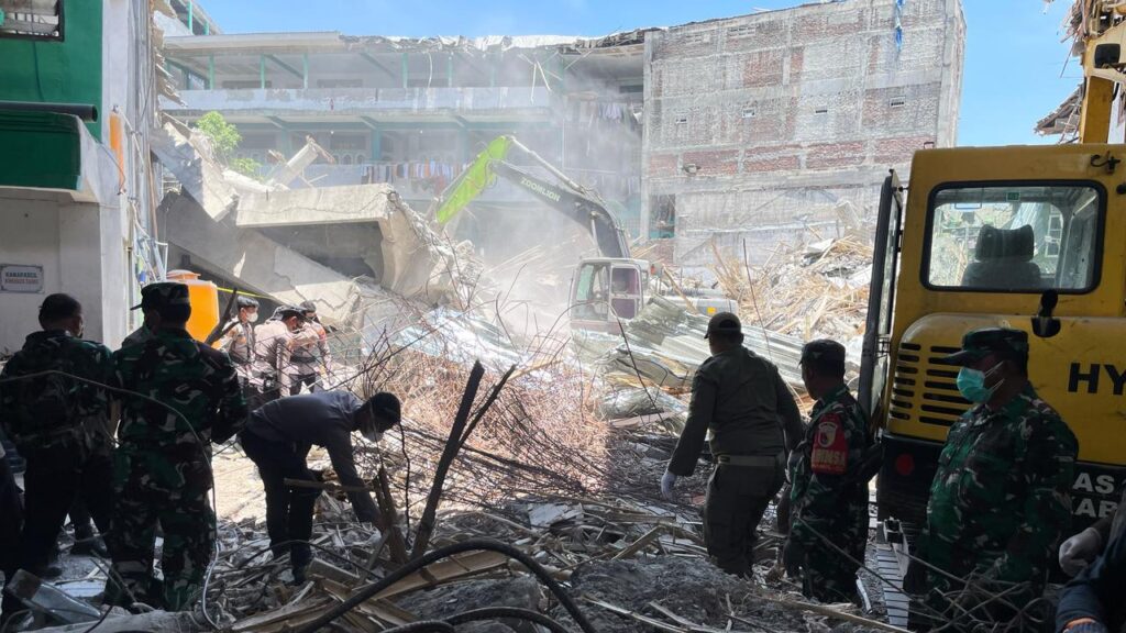 Rescuers clear rubble as they search for victims after a school building collapsed in East Java.
