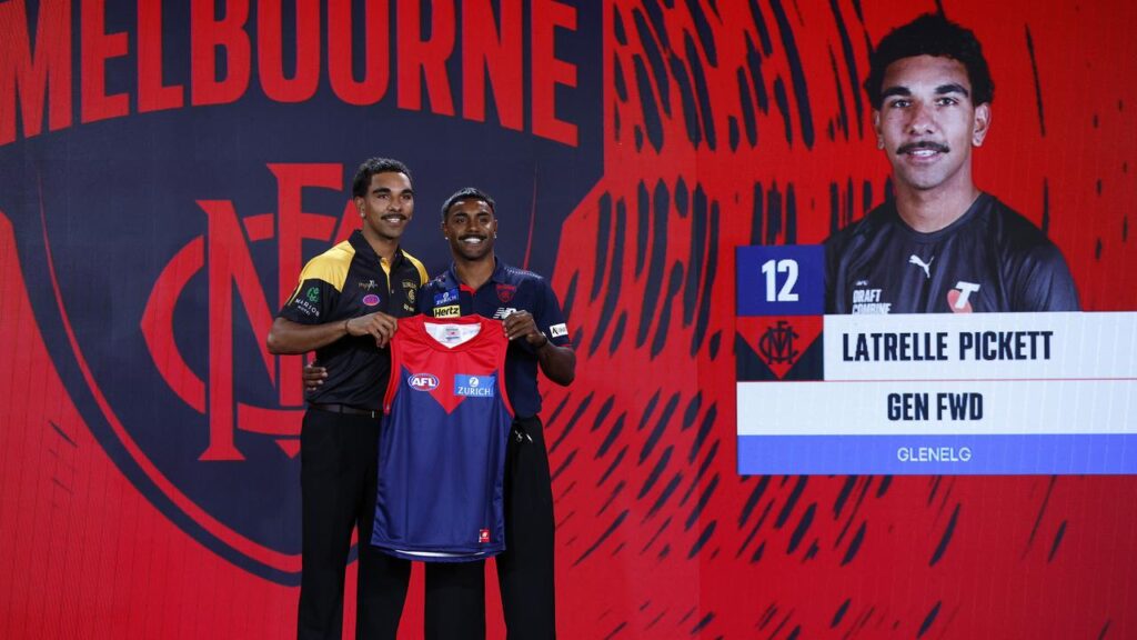 Latrelle Pickett is presented with his Melbourne guernsey by cousin Kysaiah at the AFL draft..
