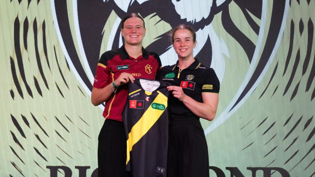 Olivia Wolmarans (l) receives her Richmond jersey from new teammate Gabby Seymour.

