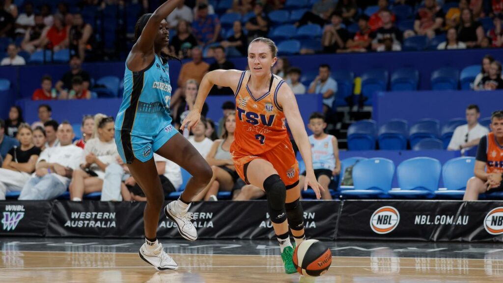 Courtney Woods, charging past Canberra’s Nyadiew Puoch, was instrumental in Townsville’s victory. 
