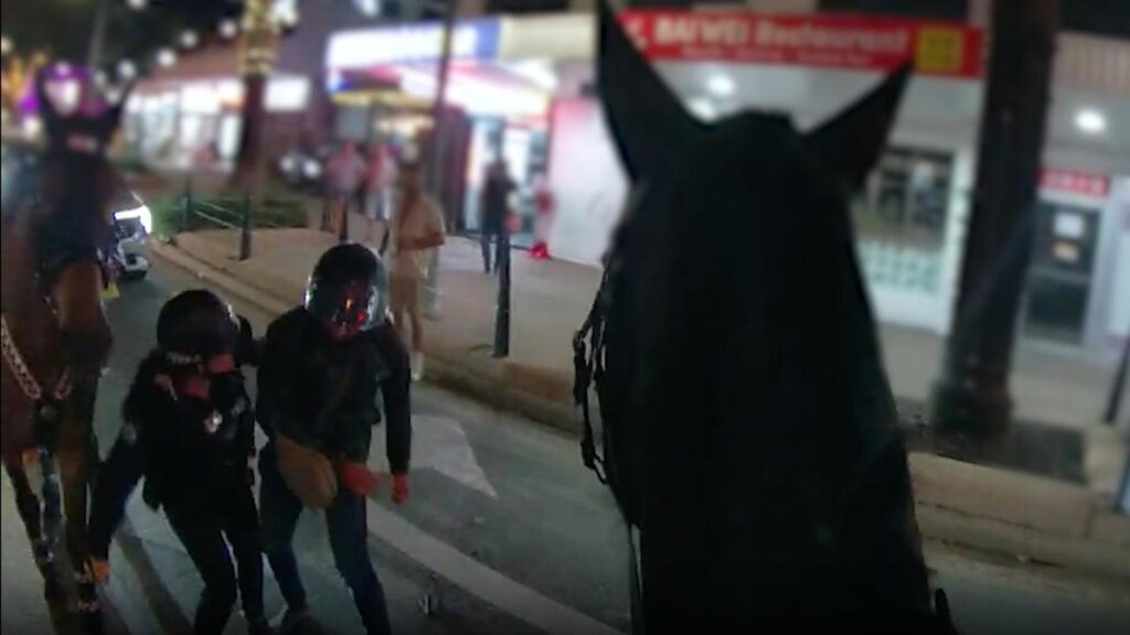 The chaotic scenes of a motorcycle colliding with two police horses was caught on body-worn cameras.
