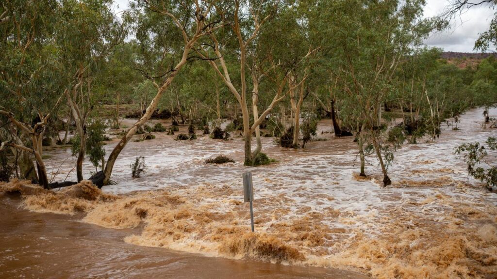 The Todd River overflowed its banks to cause flooding and a warning for residents to shelter.
