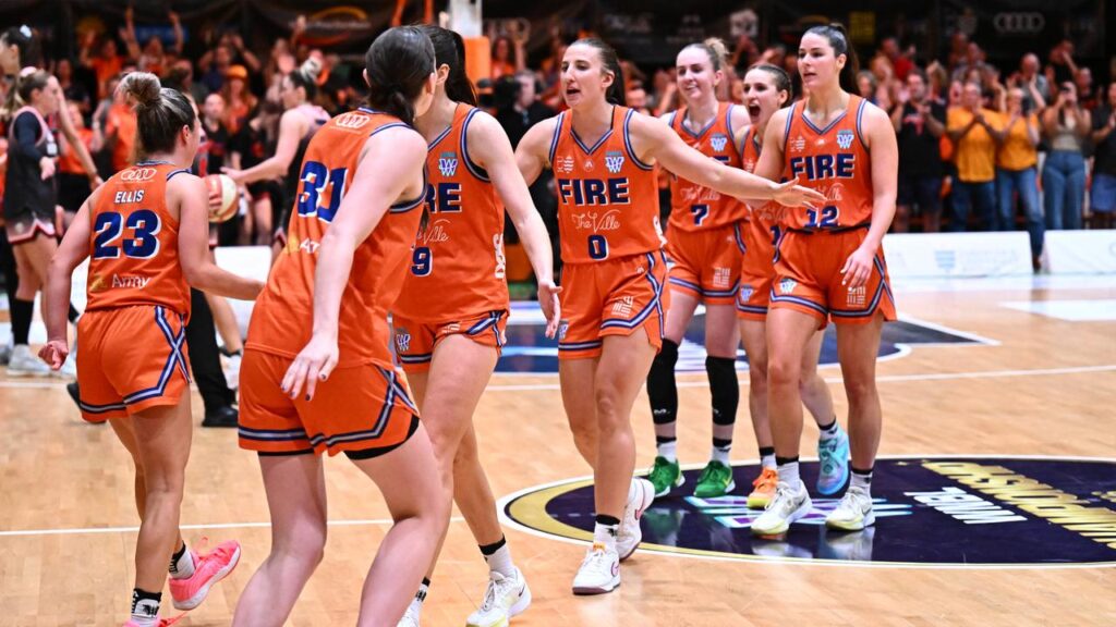 Townsville Fire celebrate after winning game one of the WNBL grand final series against Perth Lynx.
