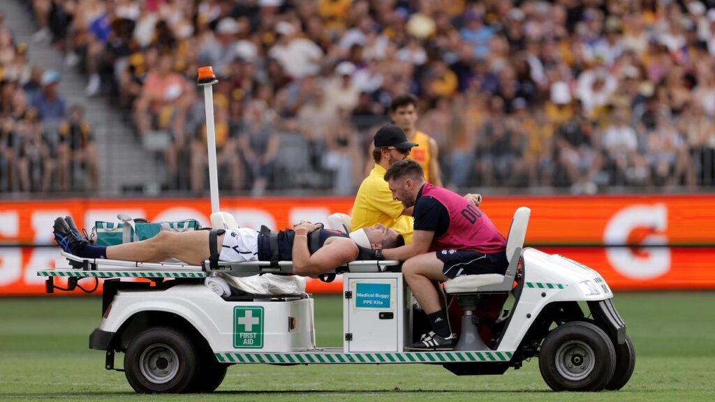 Jacob Weitering is taken from the field after a collision in AFL’s State of Origin match.
