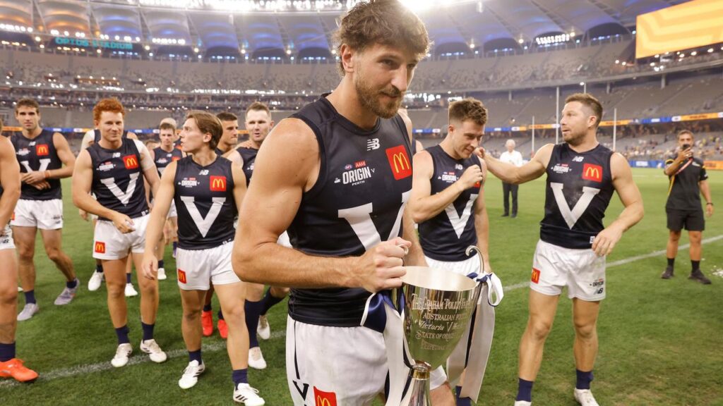 Marcus Bontempelli and his victorious Victoria teammates with the AFL Origin trophy.
