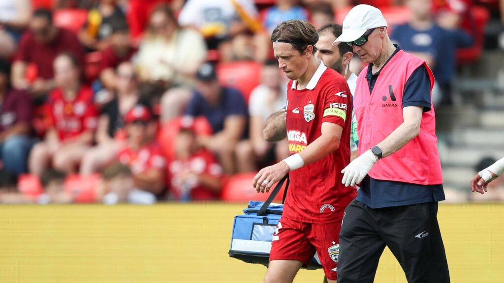 Craig Goodwin limps off during Adelaide United’s A-League loss on Sunday.
