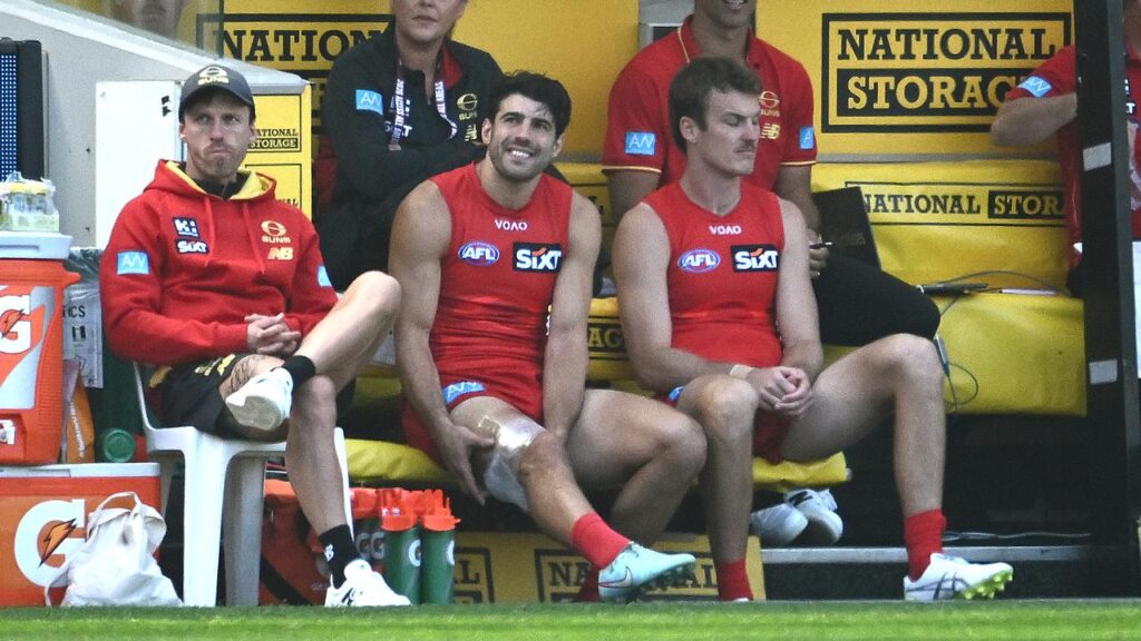 A strapped-up Christian Petracca watches from the bench as the Suns thrash the Tigers at the MCG.
