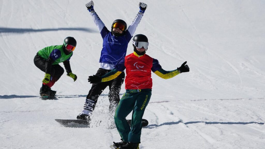 South Korean Lee Jehyuk raises his arms in triumph after beating red-vested Ben Tudhope for gold.
