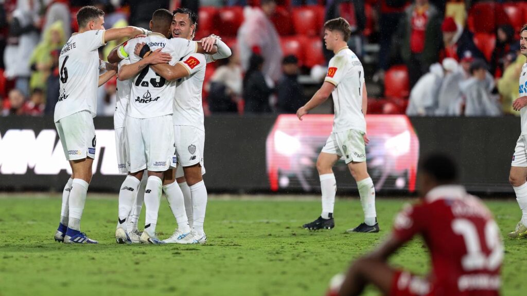 Auckland FC players celebrate reaching the grand final as Adelaide were left in despair.
