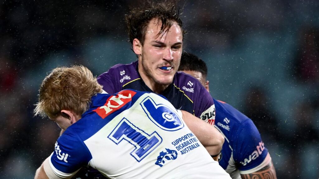 Storm’s Alec MacDonald taking a fearful hit from Bulldogs’ Jack Underhill at Accor Stadium.
