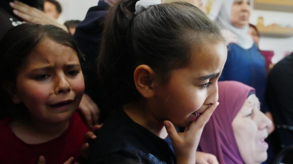 Children cry at the funeral for the Palestinian man shot  trying to climb the wall to find work.
