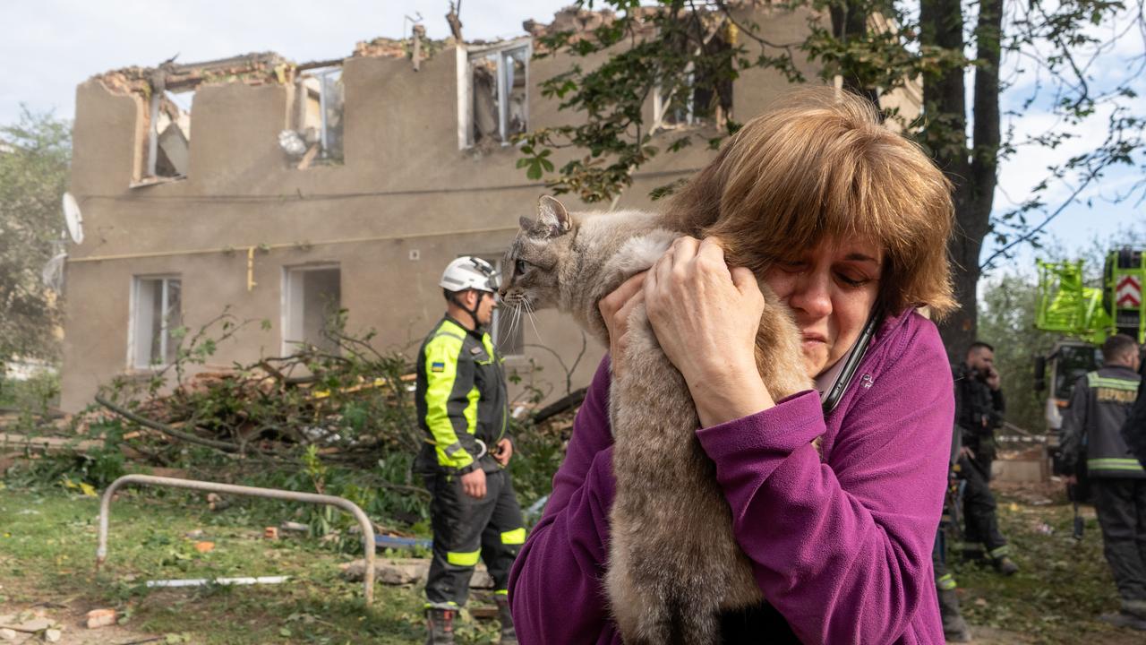 A woman holds her cat following a Russian missile attack in Kharkiv