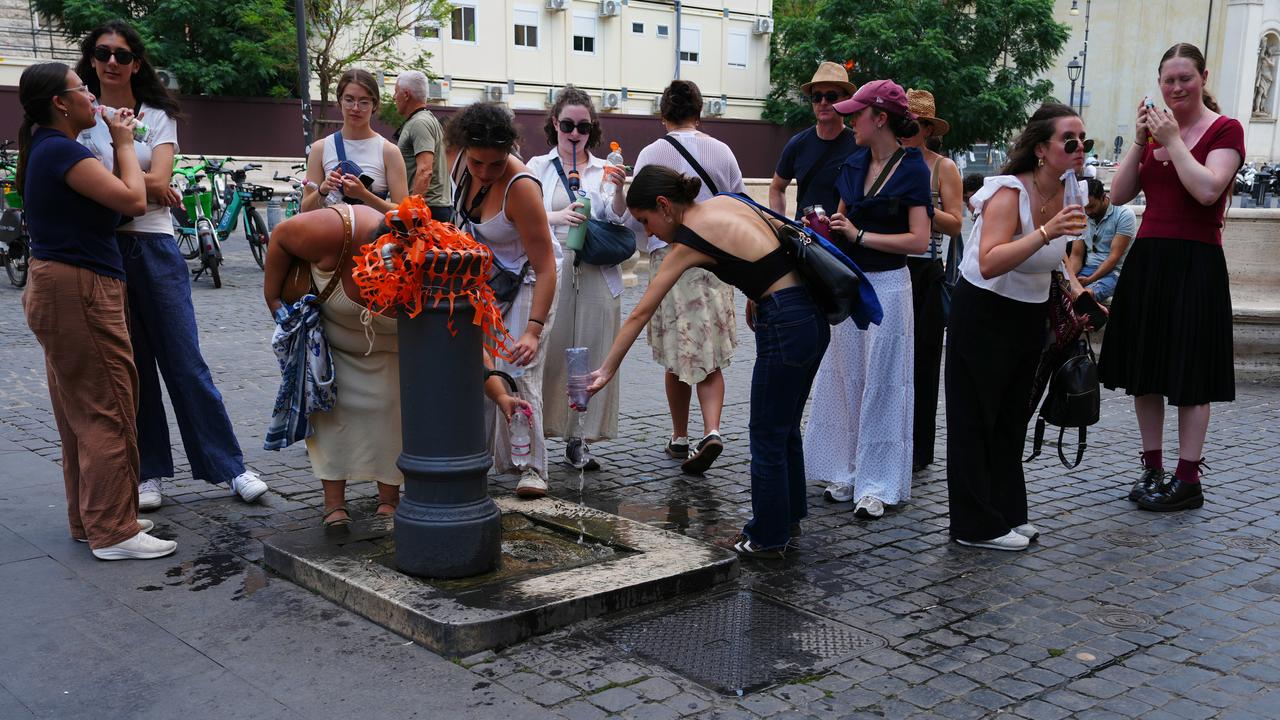 People cool off at a fountain in Rome
