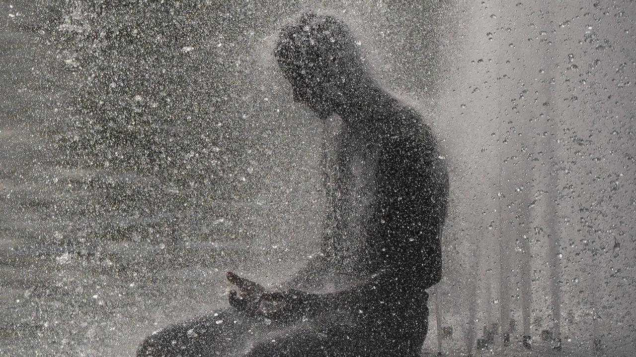 A person cools off at Trocadero fountain near the Eiffel Tower