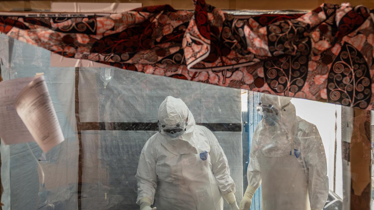 Health workers tend to an Ebola patient in DR Congo