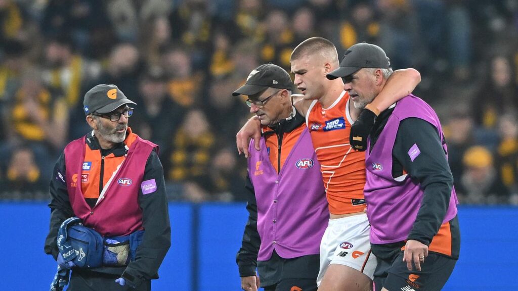 Giants forward Max Gruzewski is helped off the MCG pitch with a potential season-ending injury.
