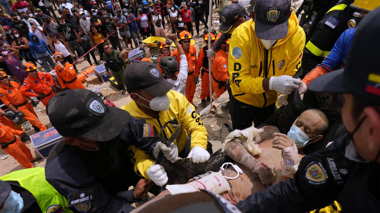 Rescue workers carry a man rescued from the rubble