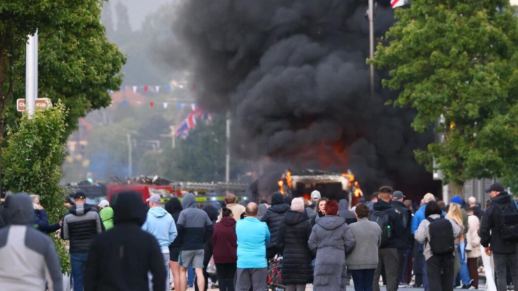 People watched on as a vehicle burned during a protest following a stabbing in Belfast.
