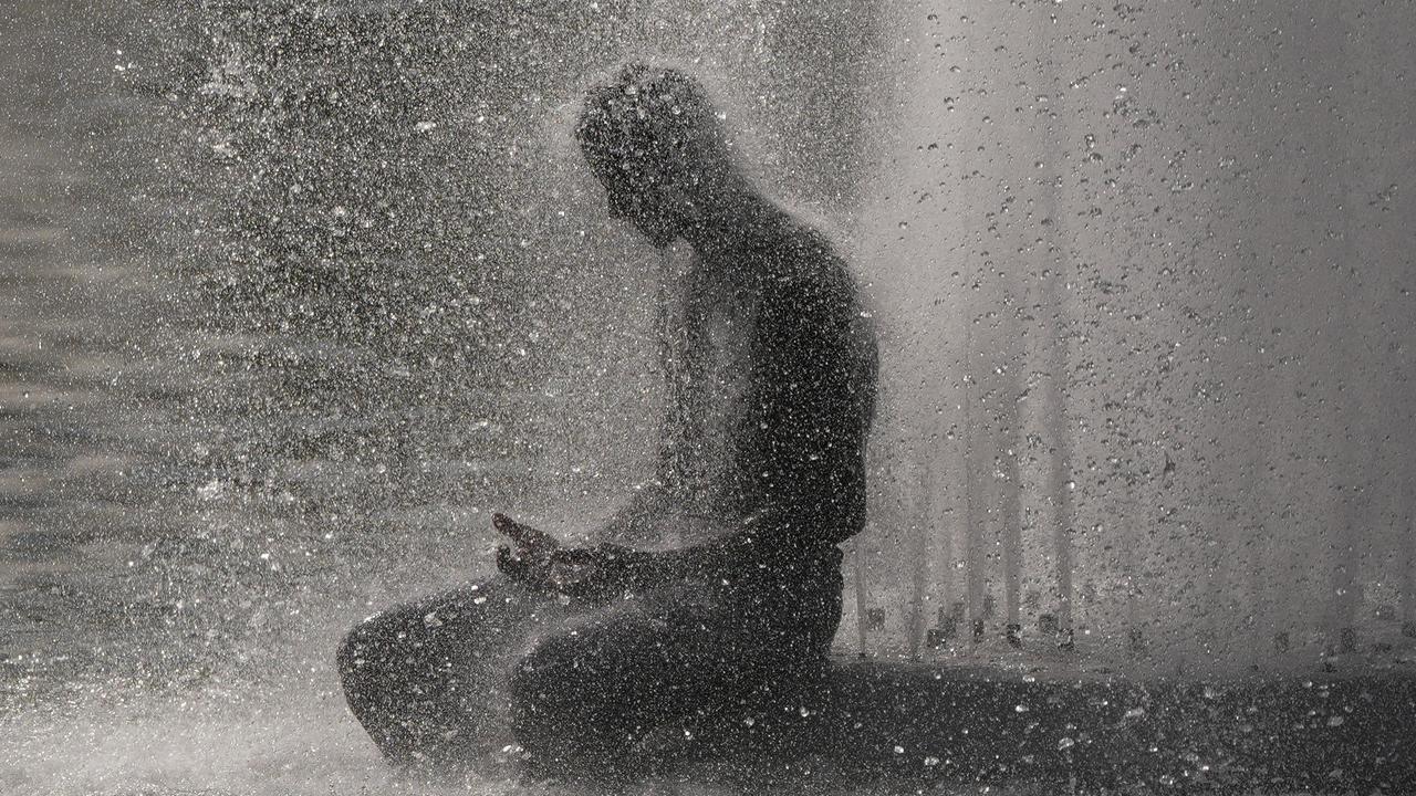 A person cools off at Trocadero fountain near the Eiffel Tower