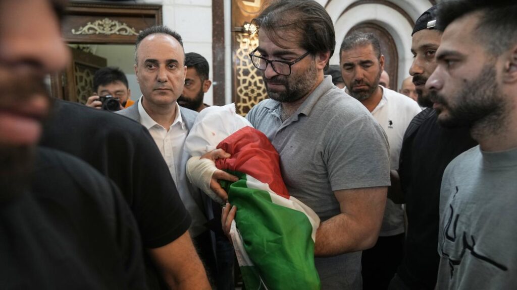 Sam Fahd Abu Haikal, wrapped in a white shroud ‌and a Palestinian flag, has been buried in Hebron.
